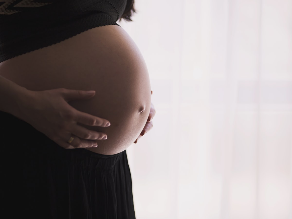 An expectant client cradling her belly